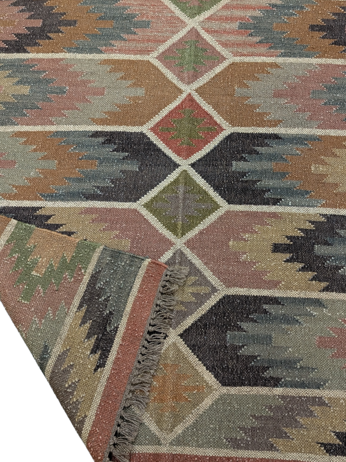 Inspired by the raw beauty of rugged landscapes, the Echoes of the Highlands Kilim Rug brings a sense of tranquility and timeless craftsmanship to your home. Handwoven by skilled artisans, this wool flatweave rug features a mesmerizing geometric design with earthy hues of sage green, terracotta, charcoal, soft beige, and muted blues, evoking the essence of misty highlands and rolling hills. Its intricate diamond motifs and horizontal patterns create a harmonious blend of tradition and modernity, making it a