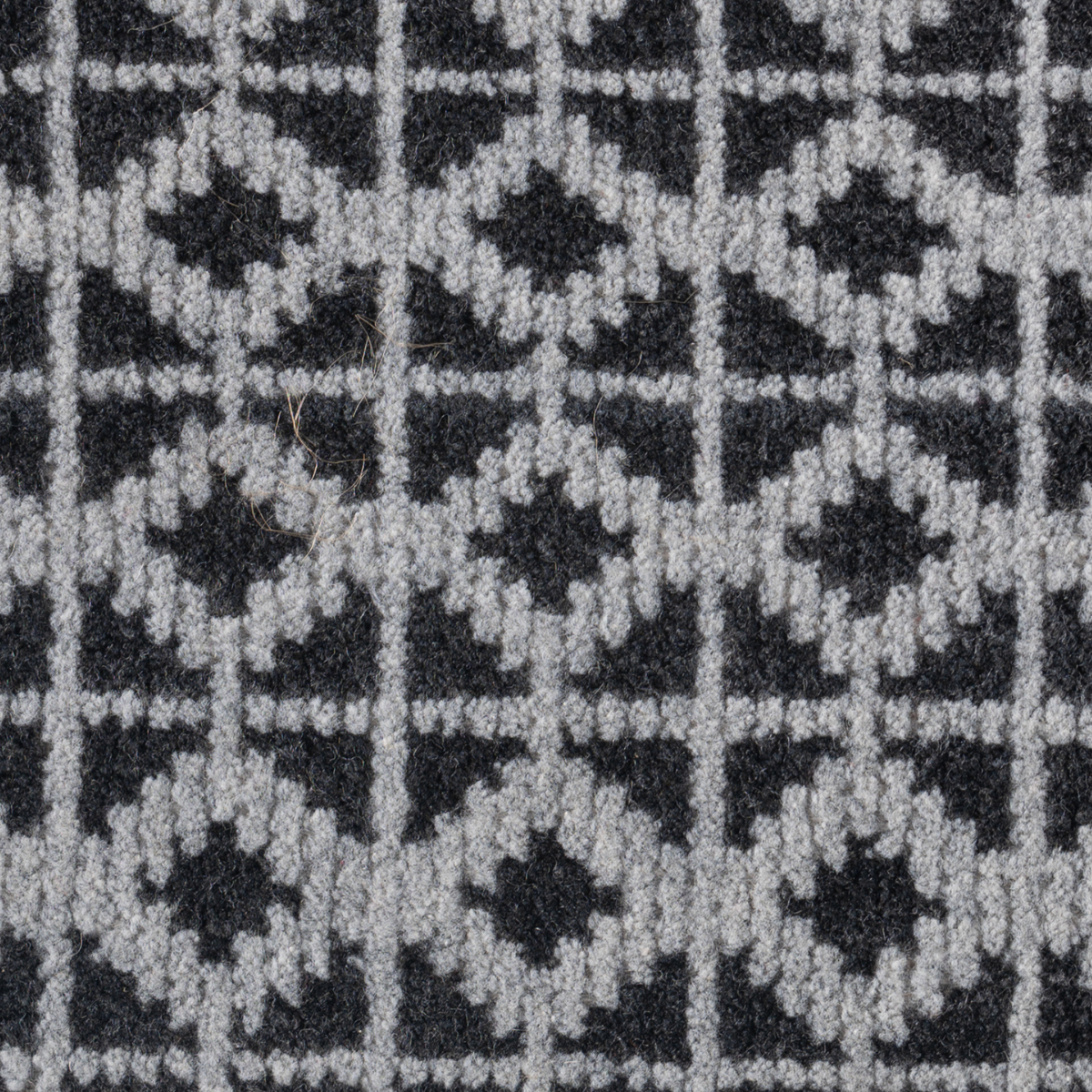 Artisan's Trace : Steel Loom close-up showing the wool weave and geometric motif
