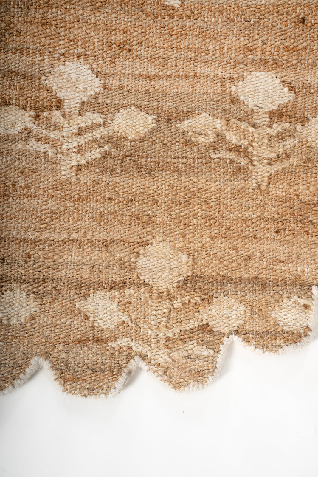 Ivory Bloom Scalloped Jute Rug jute rug styled in a living room interior