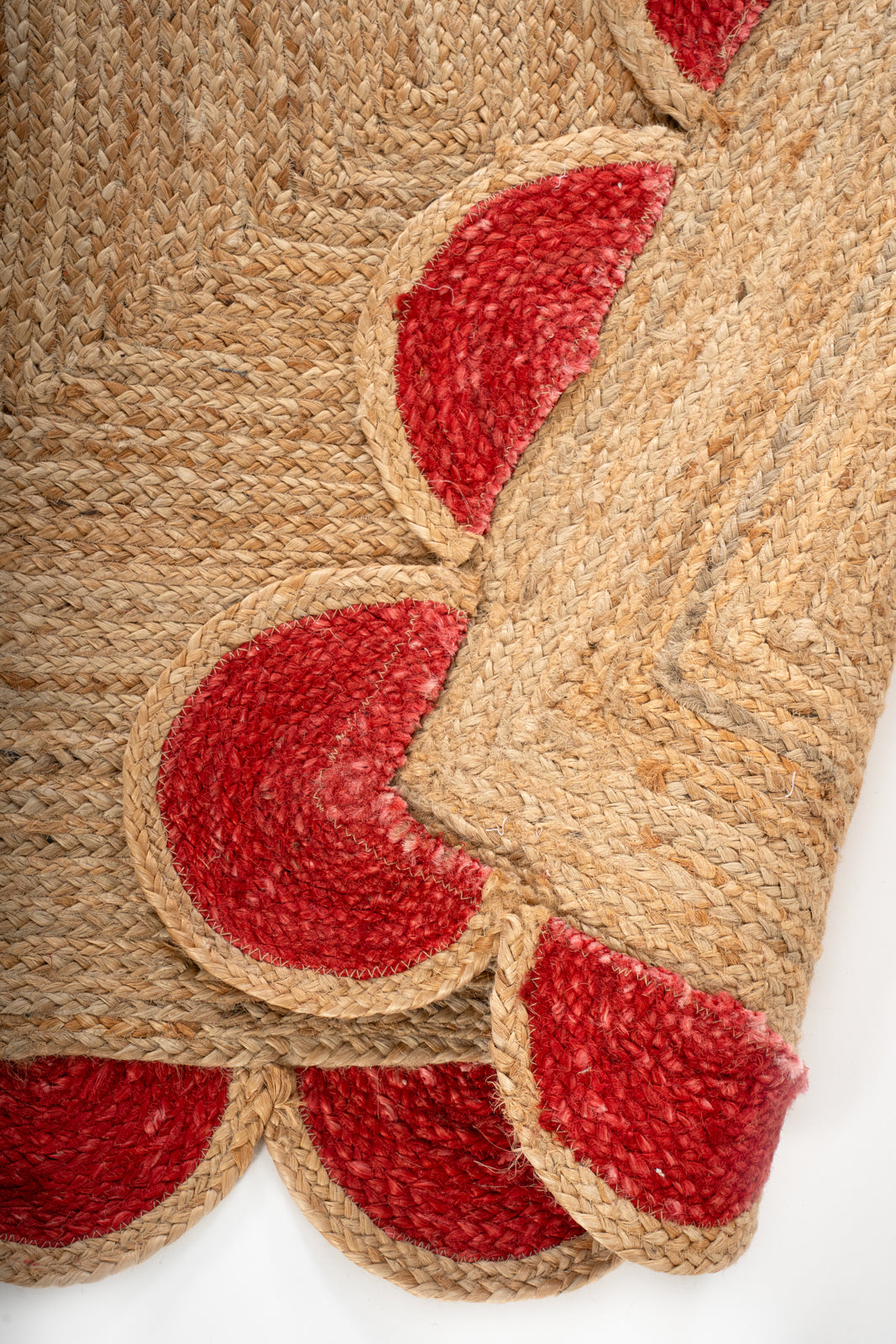 Kribi scalloped jute area rug-Cherry red detail showing the textured jute surface and finishing