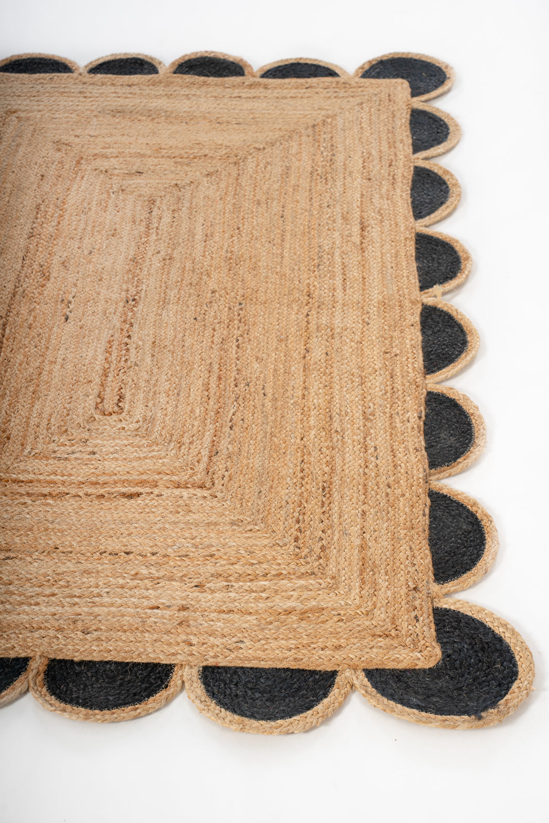 Kribi scalloped jute area rug-Jet Black jute rug styled in a living room interior