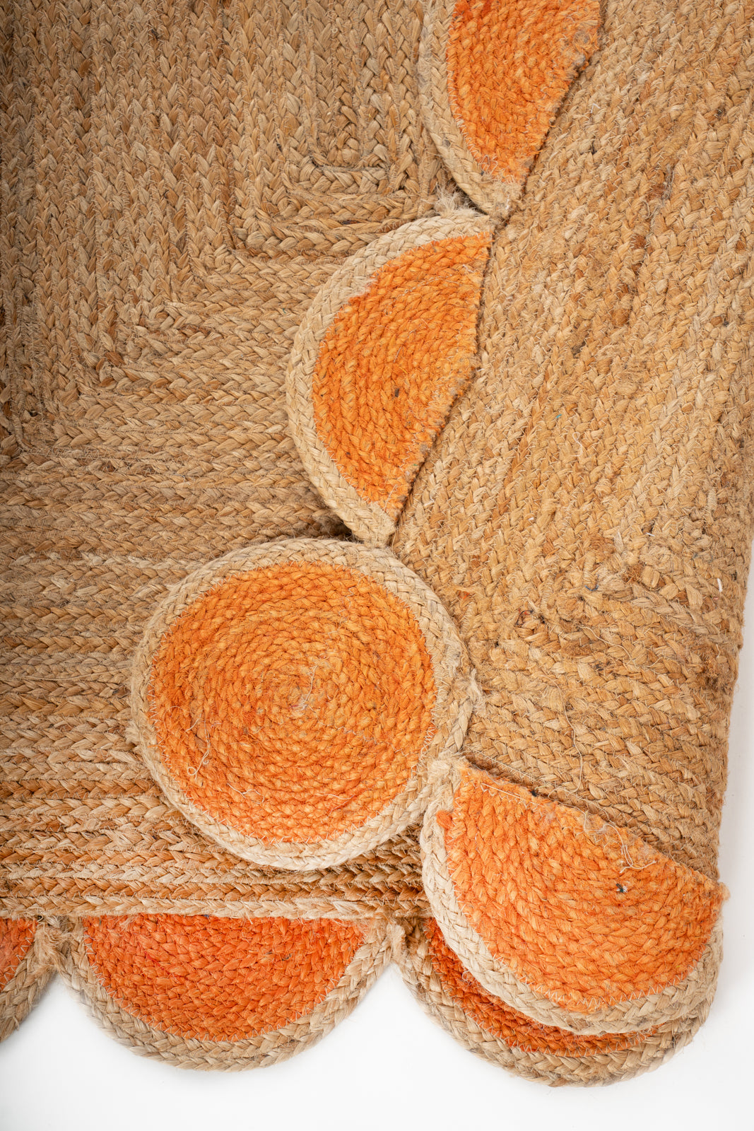 Kribi scalloped jute area rug-Orange detail showing the textured jute surface and finishing