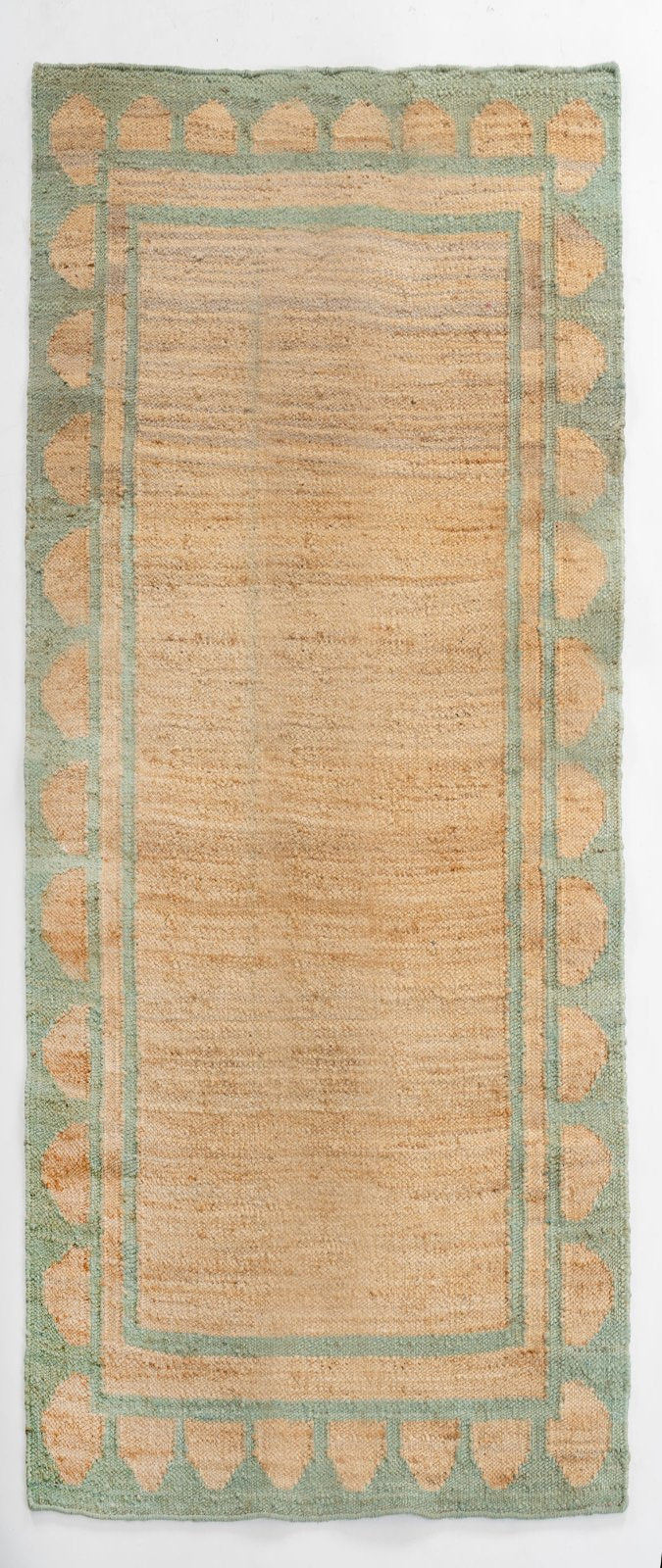 Lira Scalloped Hemp Runner in hemp, laid along a staircase to show full length and proportion