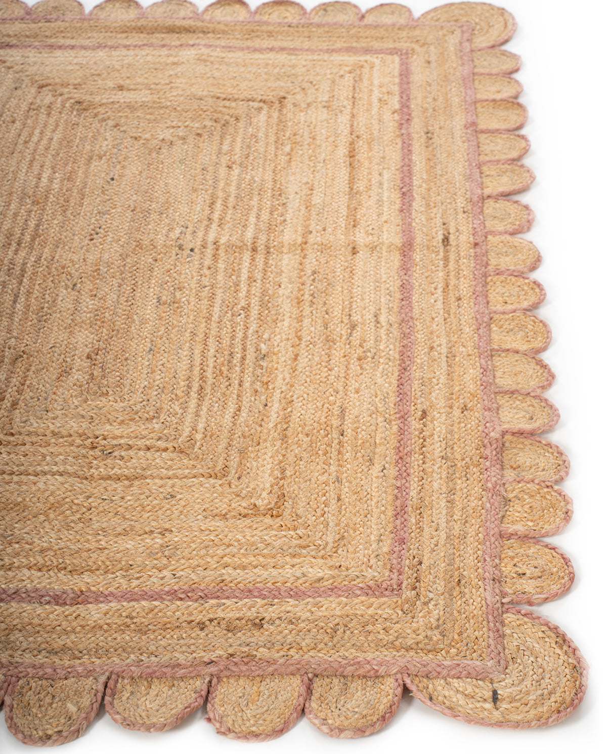 Loko scalloped jute braided area rug-Dusky Pink jute rug styled in a living room interior
