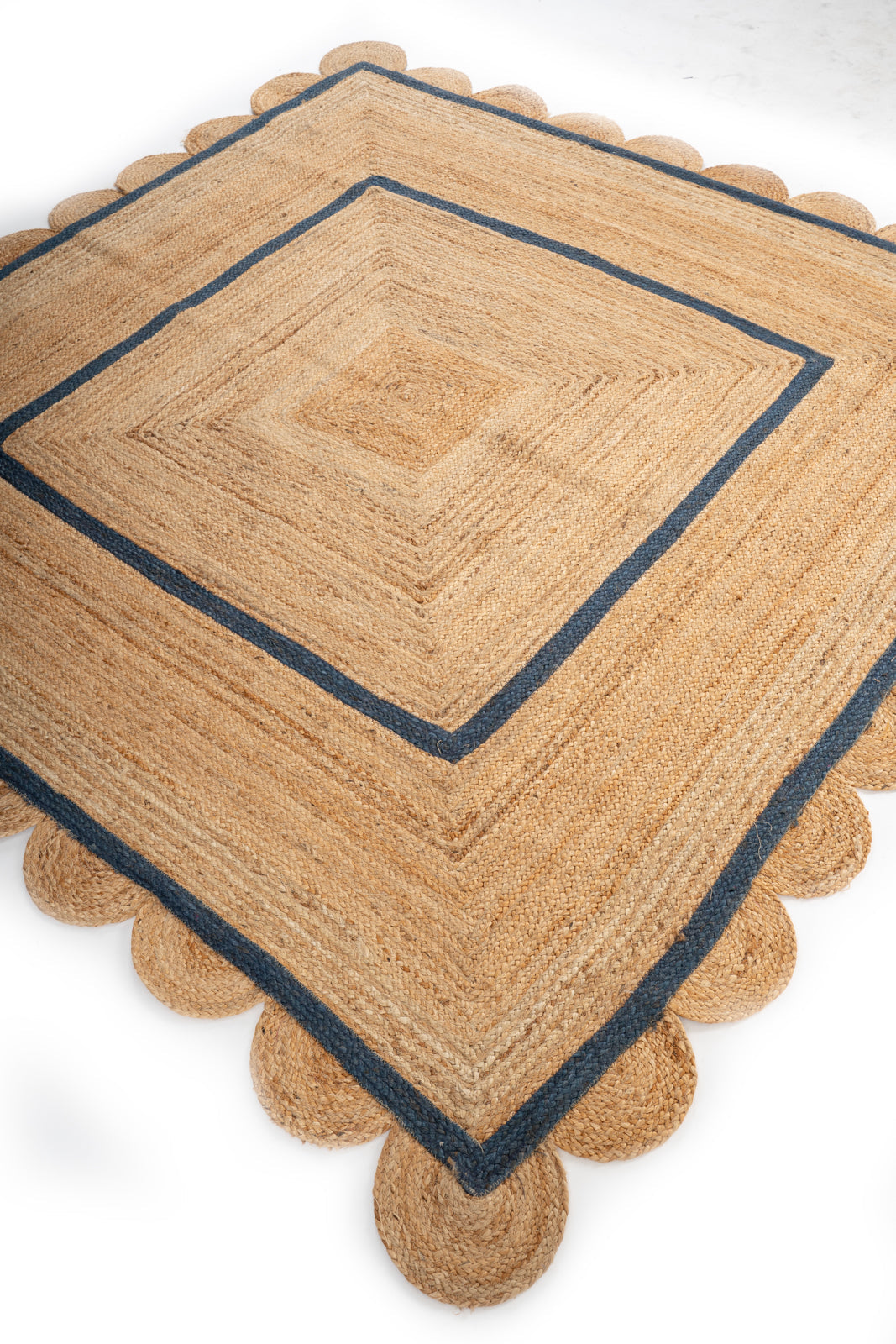 Loko scalloped square jute rug-Navy jute rug styled in a living room interior