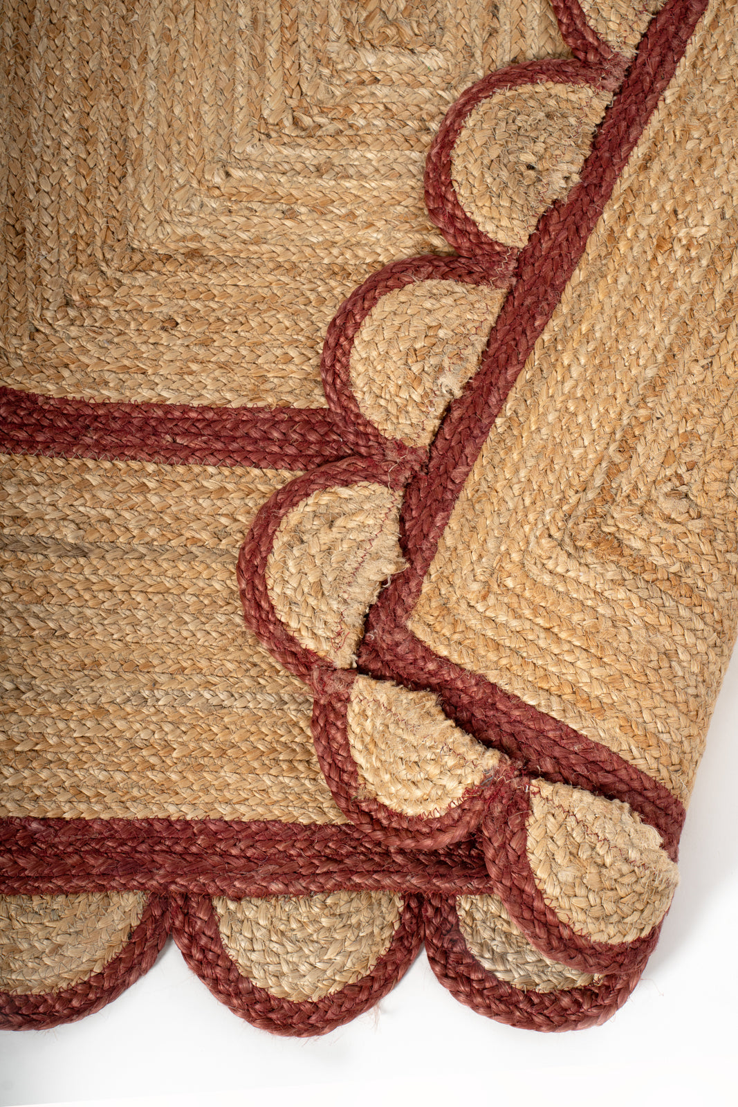 Loko scalloped square jute rug-Red detail showing the textured jute surface and finishing