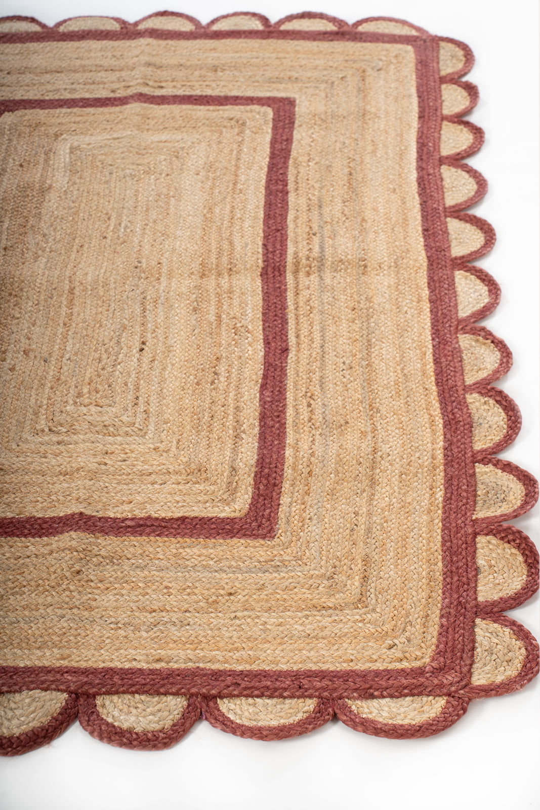 Loko scalloped square jute rug-Red jute rug styled in a living room interior