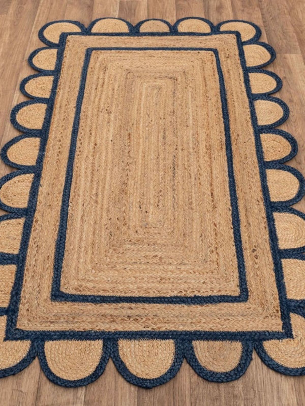 Luxor scalloped braided area rug-Navy cotton rug styled in a living room interior