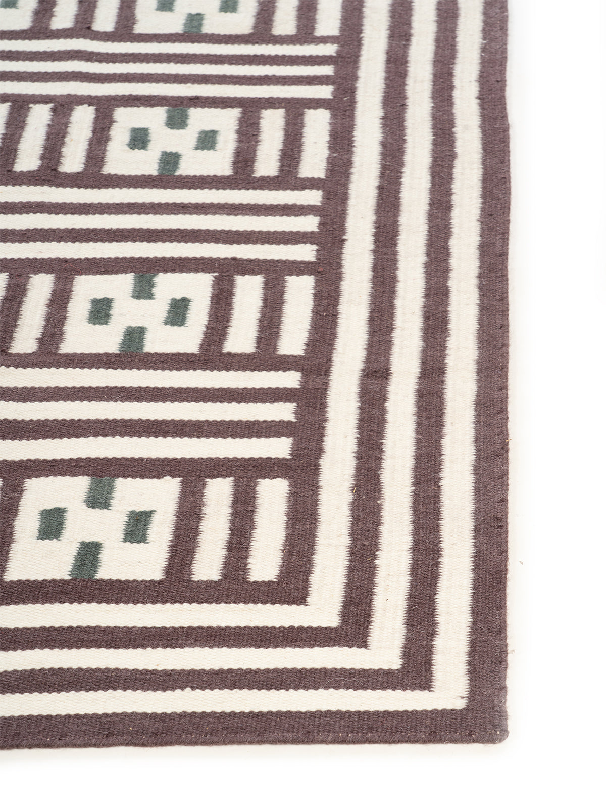 Maltese Cross Flatweave Rug wool rug styled in a living room interior