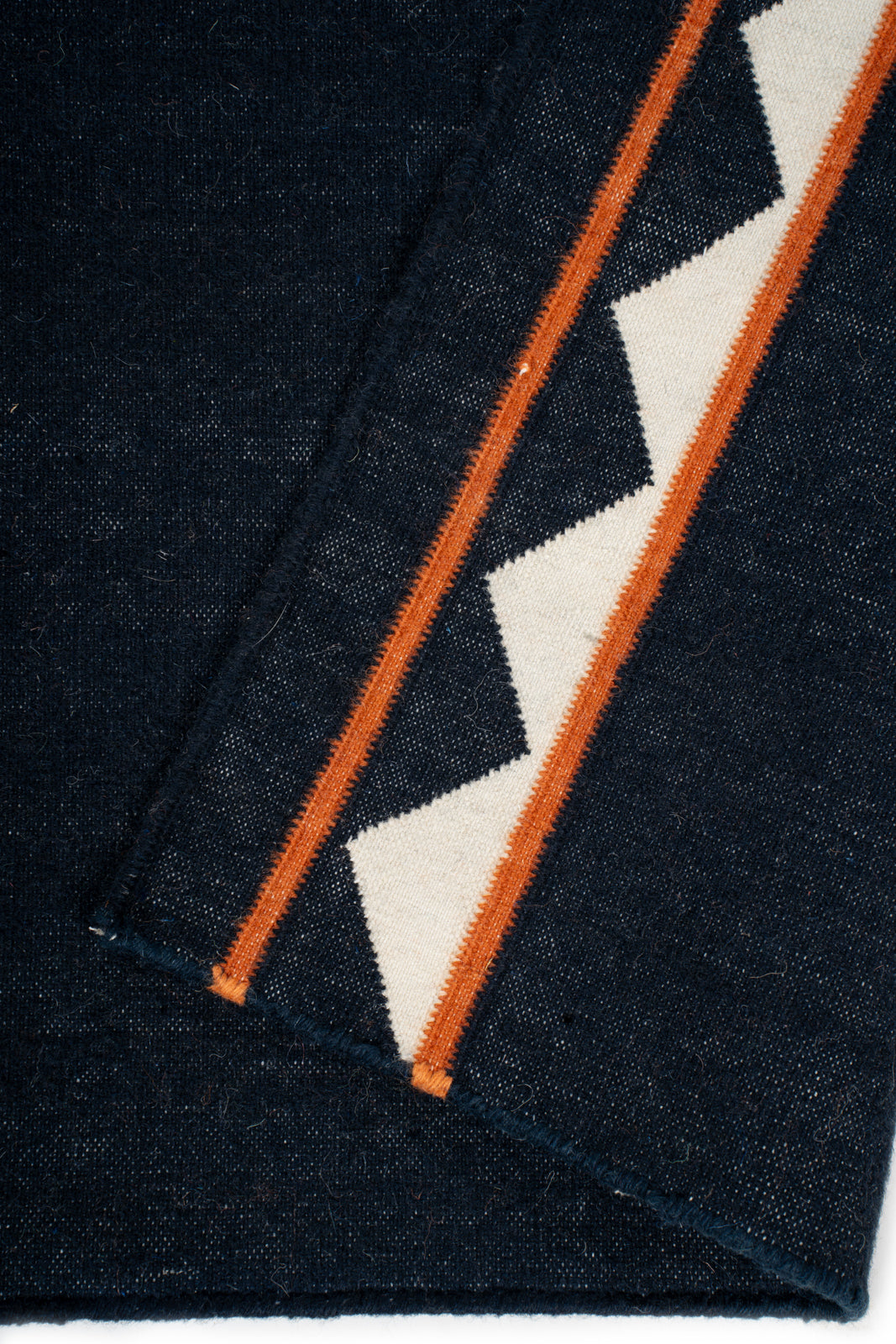 Midnight Ember Dhurrie Runner detail showing edge binding and cotton finishing of the runner