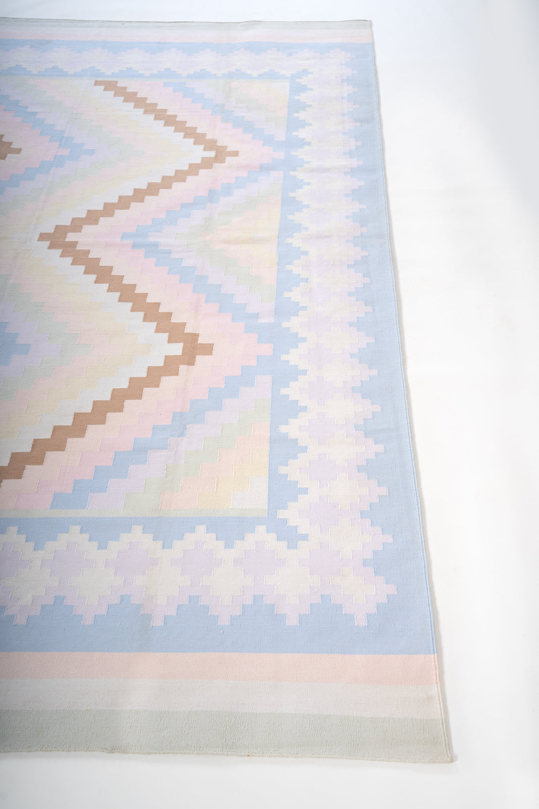 Pastel Udaipur Chevron Dhurrie cotton rug styled in a living room interior