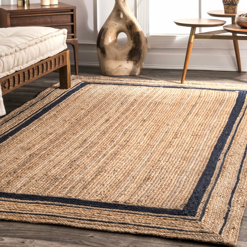 Suez bordered jute braided area rug-Navy jute rug styled in a living room interior with timber and linen