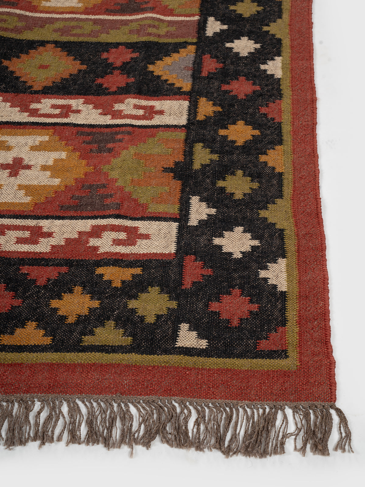The Charcoal Medley Kilim wool rug styled in a living room interior