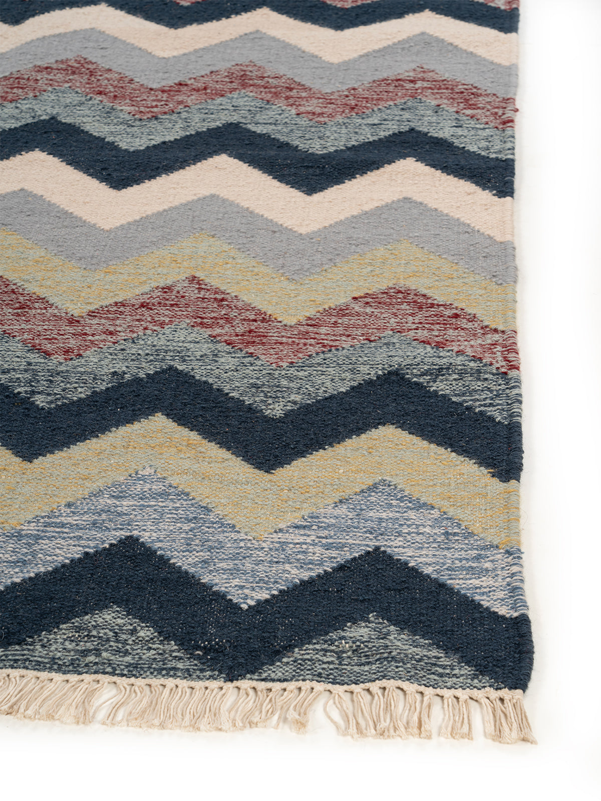 The Coastal Chevron Rug wool rug styled in a living room interior