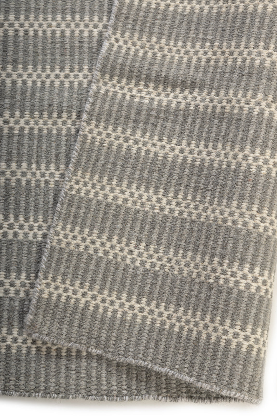 The Linear Calm detail of the striped wool surface and edge finishing