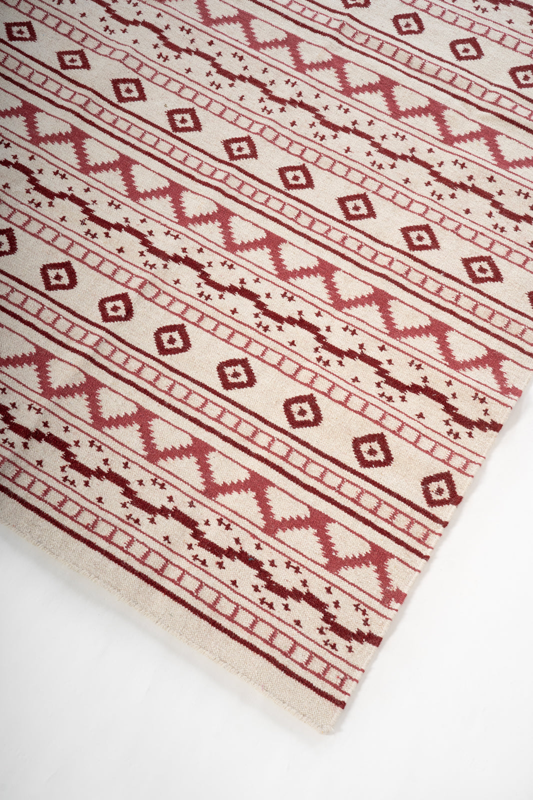 Bhuj Crimson Weave Rug close-up showing the wool weave and traditional motif