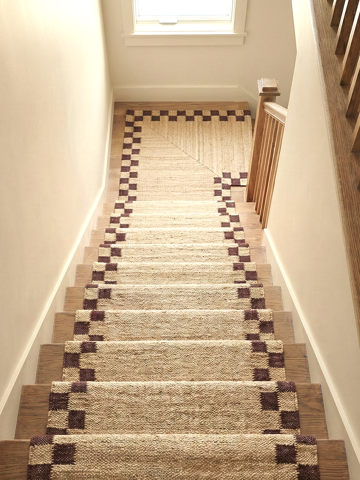 Checkerboard Border Jute Runner jute stair runner styled on a staircase in a designed interior