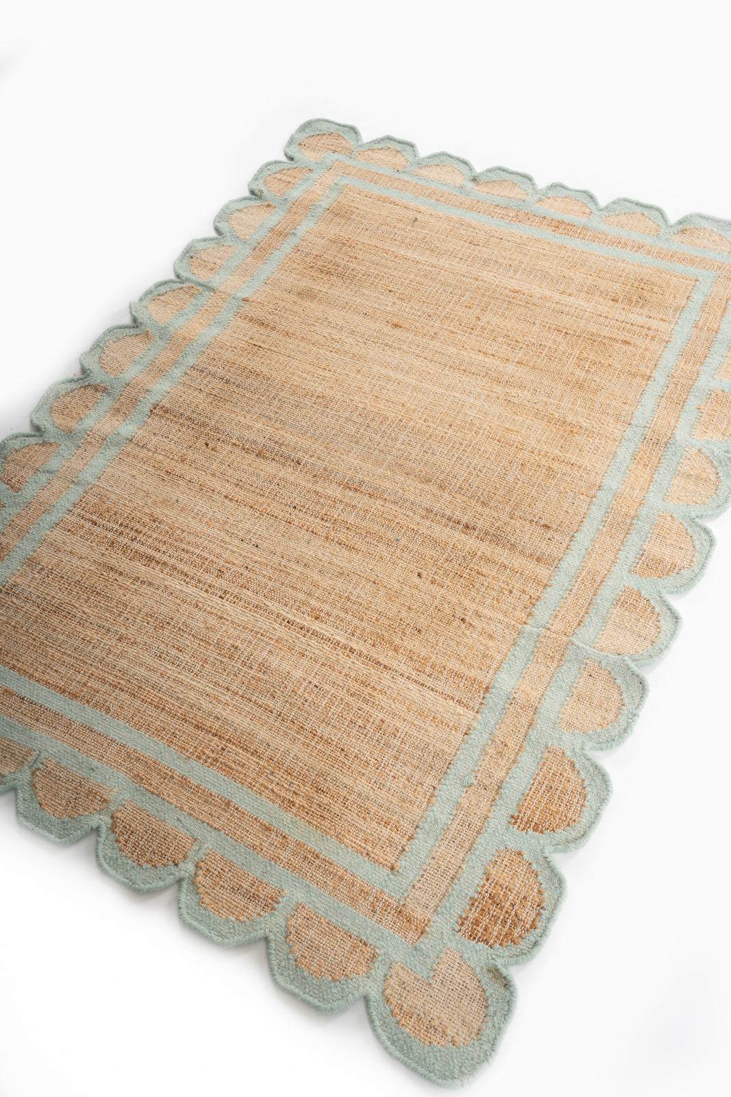 Kigali scalloped hemp rug-Mint green hemp rug styled in a living room interior