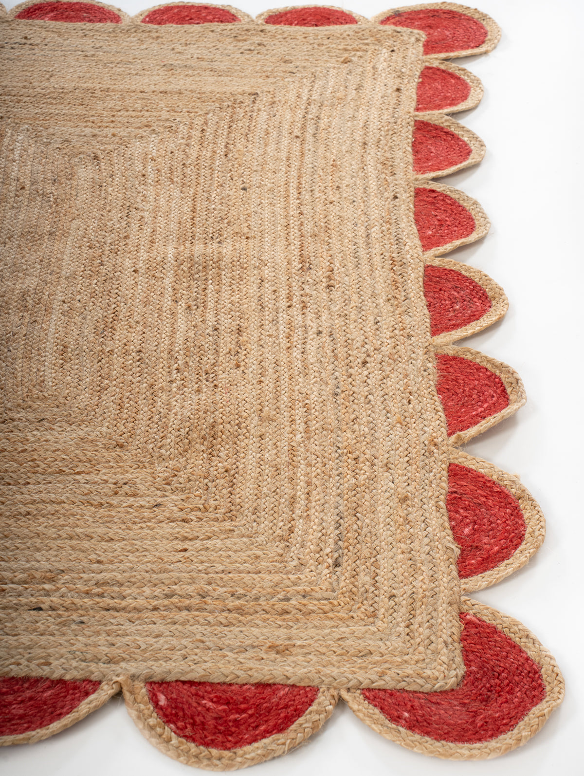 Kribi scalloped jute area rug-Cherry red jute rug styled in a living room interior