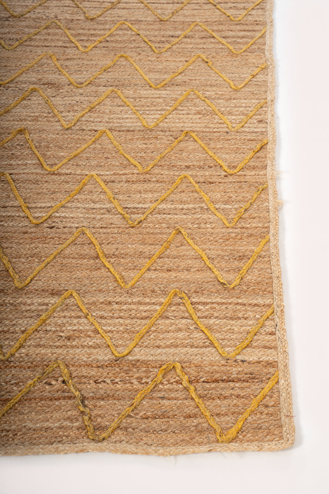 Lagos Zig Zag Braided Rug-Yellow jute rug styled in a living room interior