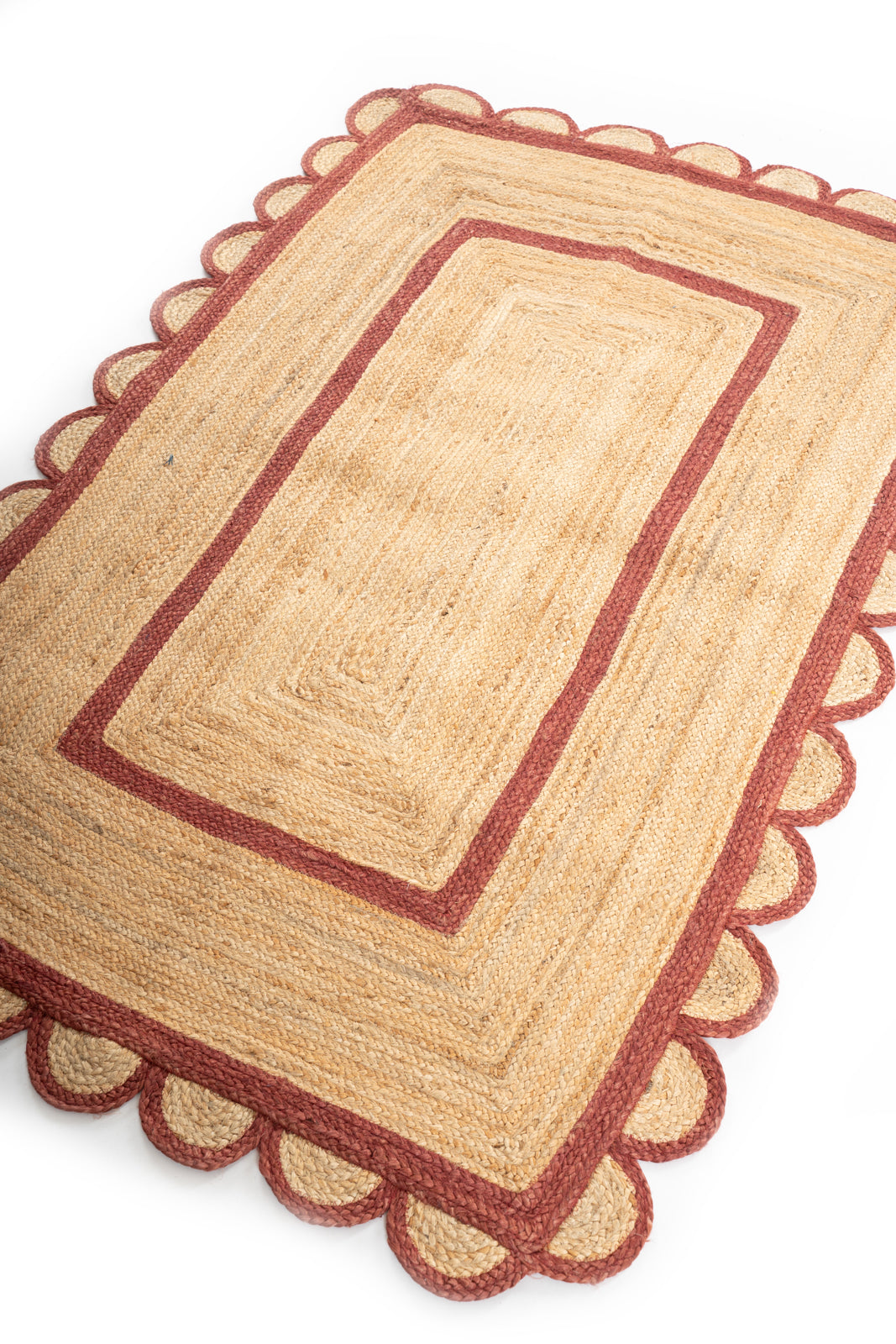 Luxor scalloped braided area rug-Red cotton rug styled in a living room interior