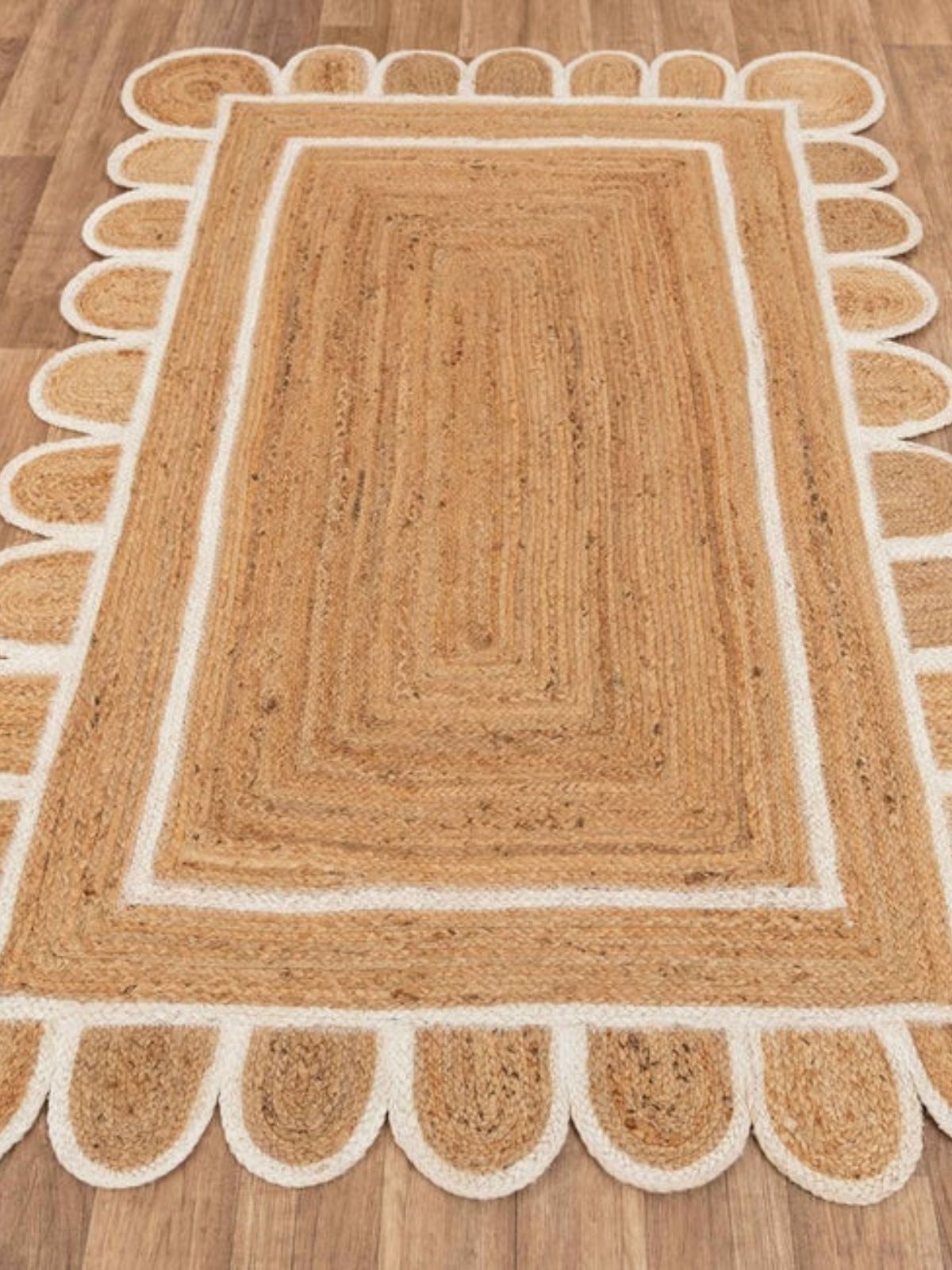 Luxor scalloped braided area rug-White cotton rug styled in a living room interior