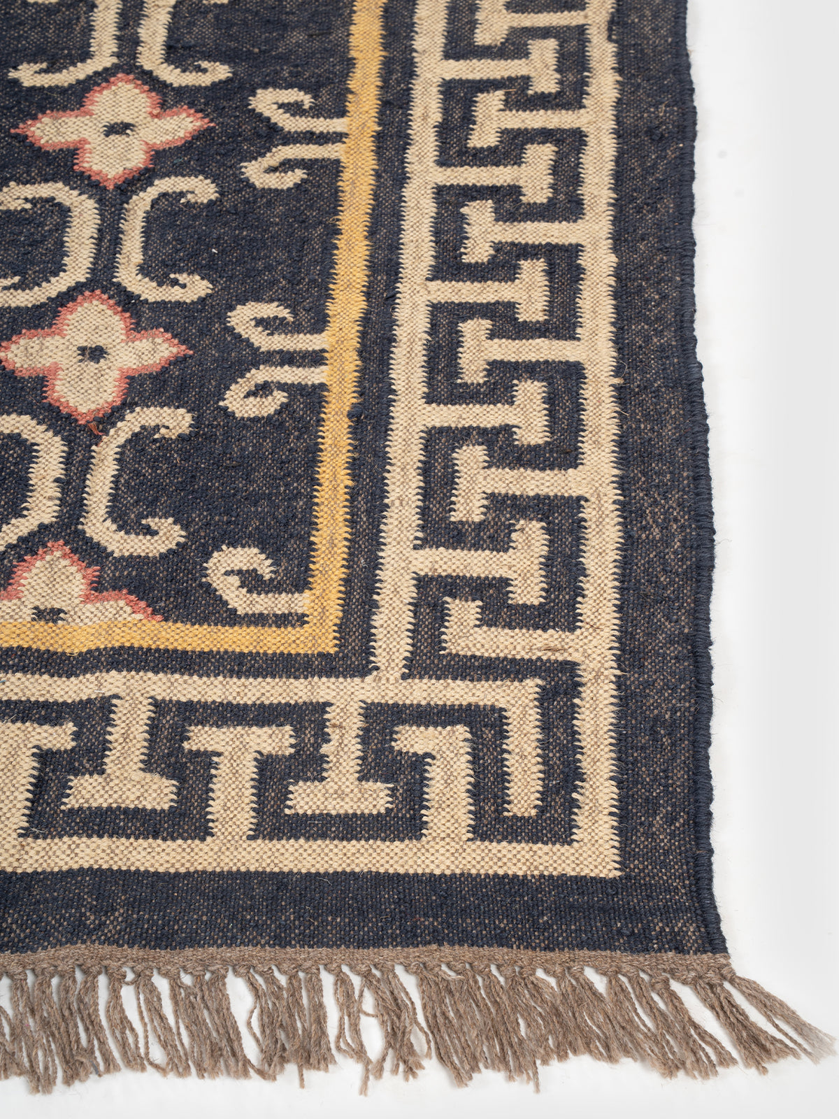The Aegean Key Rug wool rug styled in a living room interior