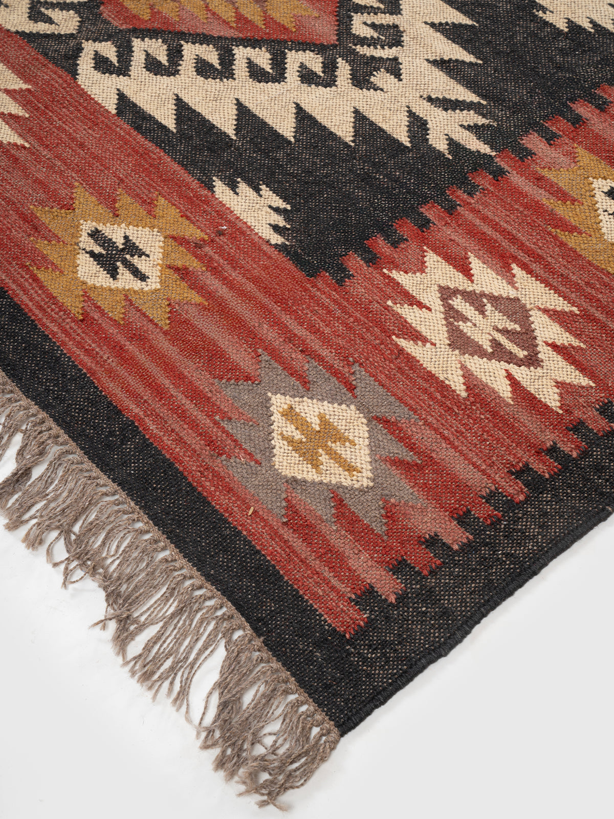 The Ancestral Column Rug close-up showing the wool weave and traditional motif