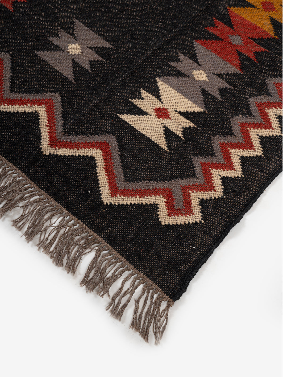 The Charcoal Peak Rug close-up showing the wool weave and geometric motif