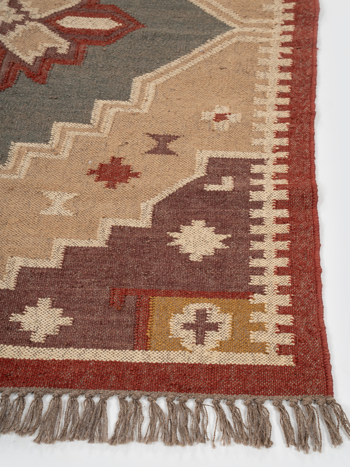 The Fortress Shield Kilim wool rug styled in a living room interior