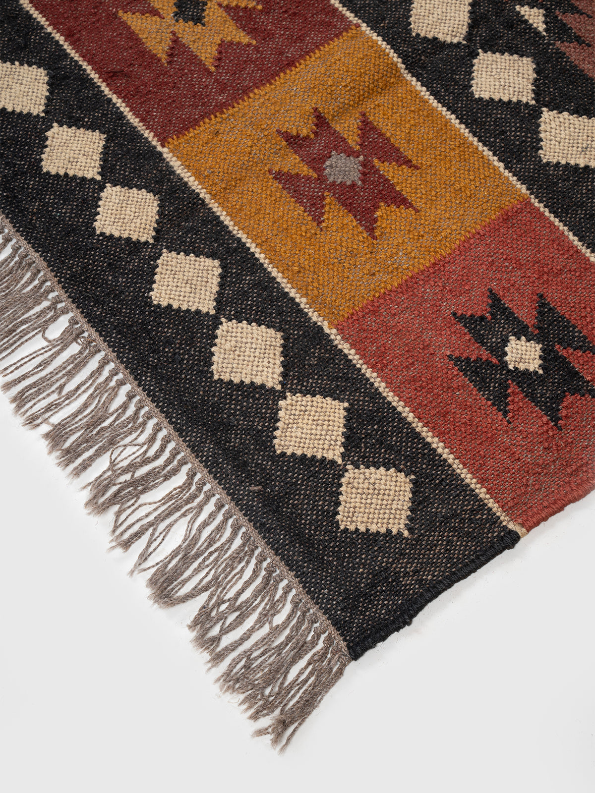 The Iron Grid Rug close-up showing the wool weave and geometric motif