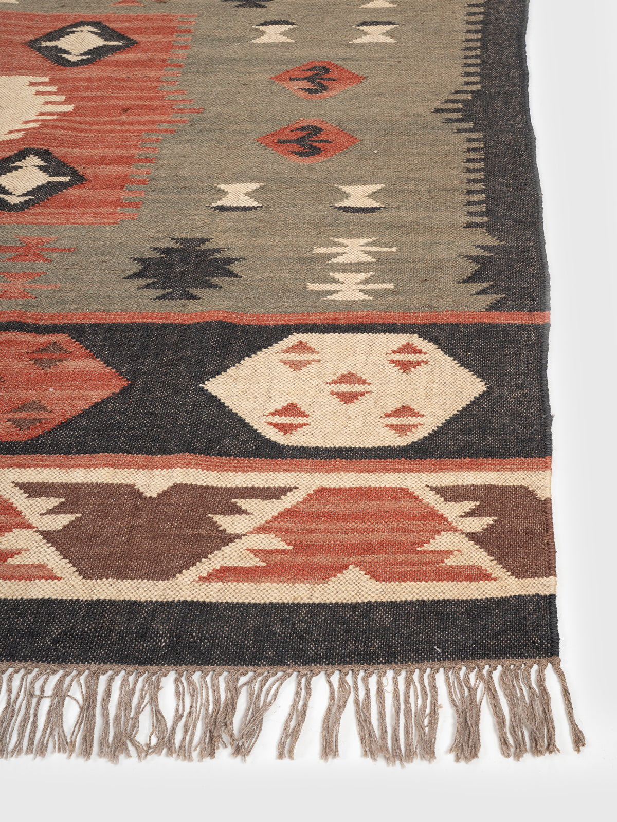 The Olive Talisman Rug wool rug styled in a living room interior