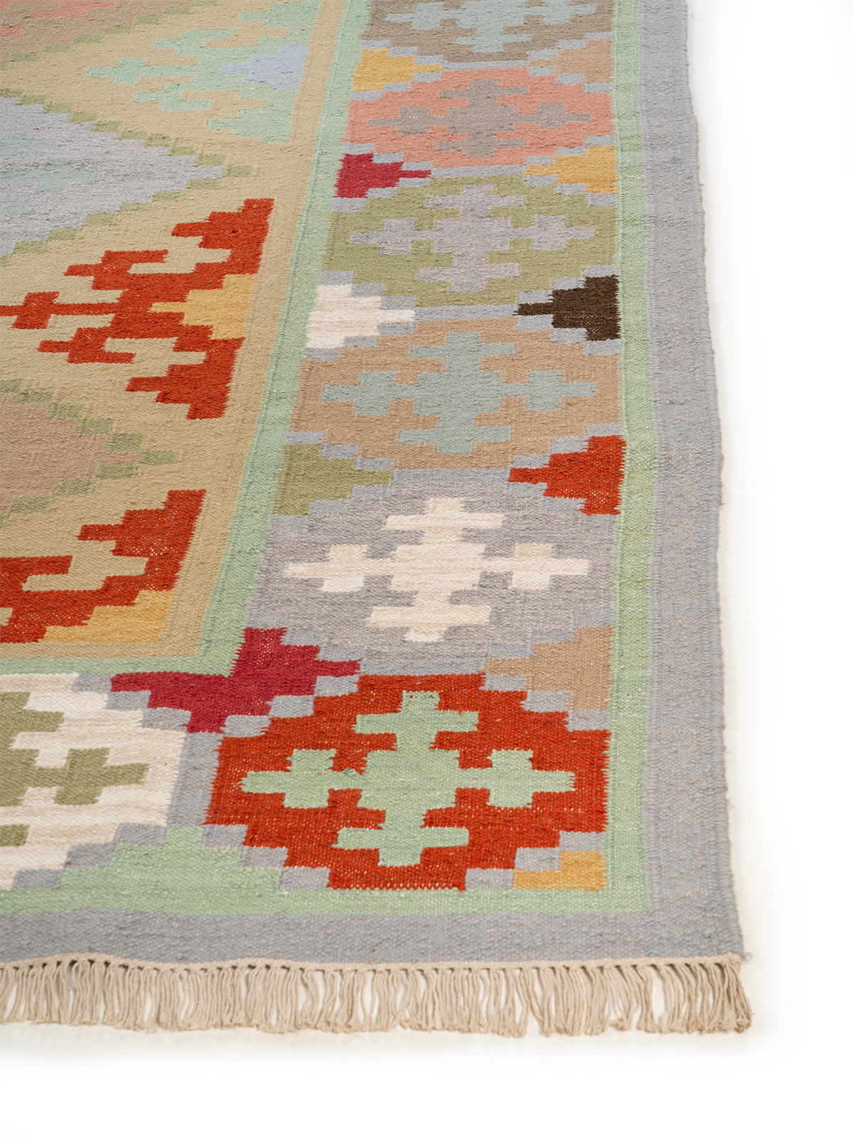 The Pastel Mosaic Rug wool rug styled in a living room interior