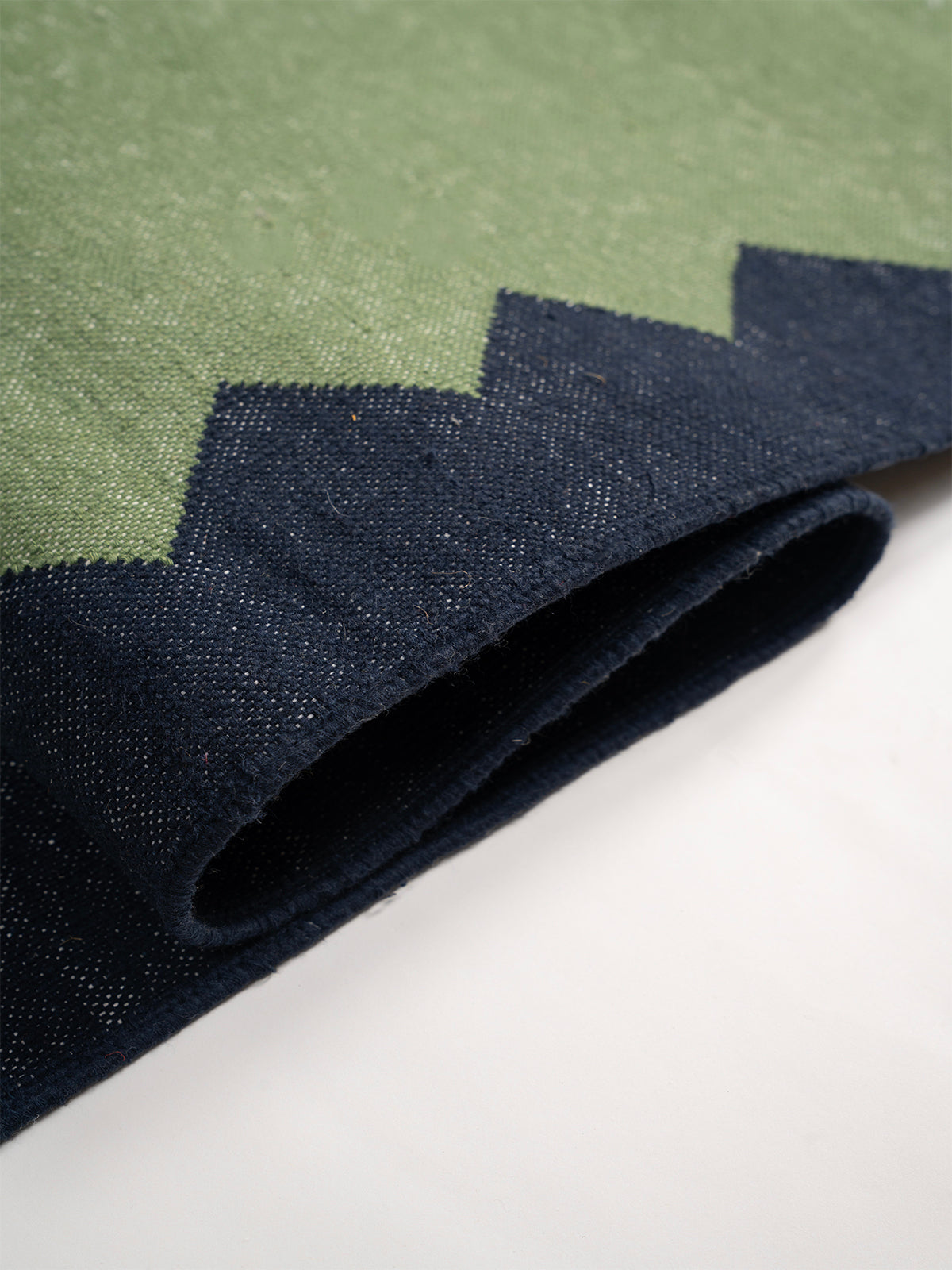 The Zigzag Trail Runner- Muted moss - cotton runner laid in a hallway view